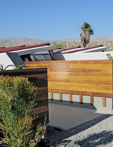 wood clad ranch style homes connected in a desert landscape and gravel drive