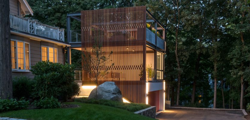 glowing 3-story garage studio steel structure with wood screen