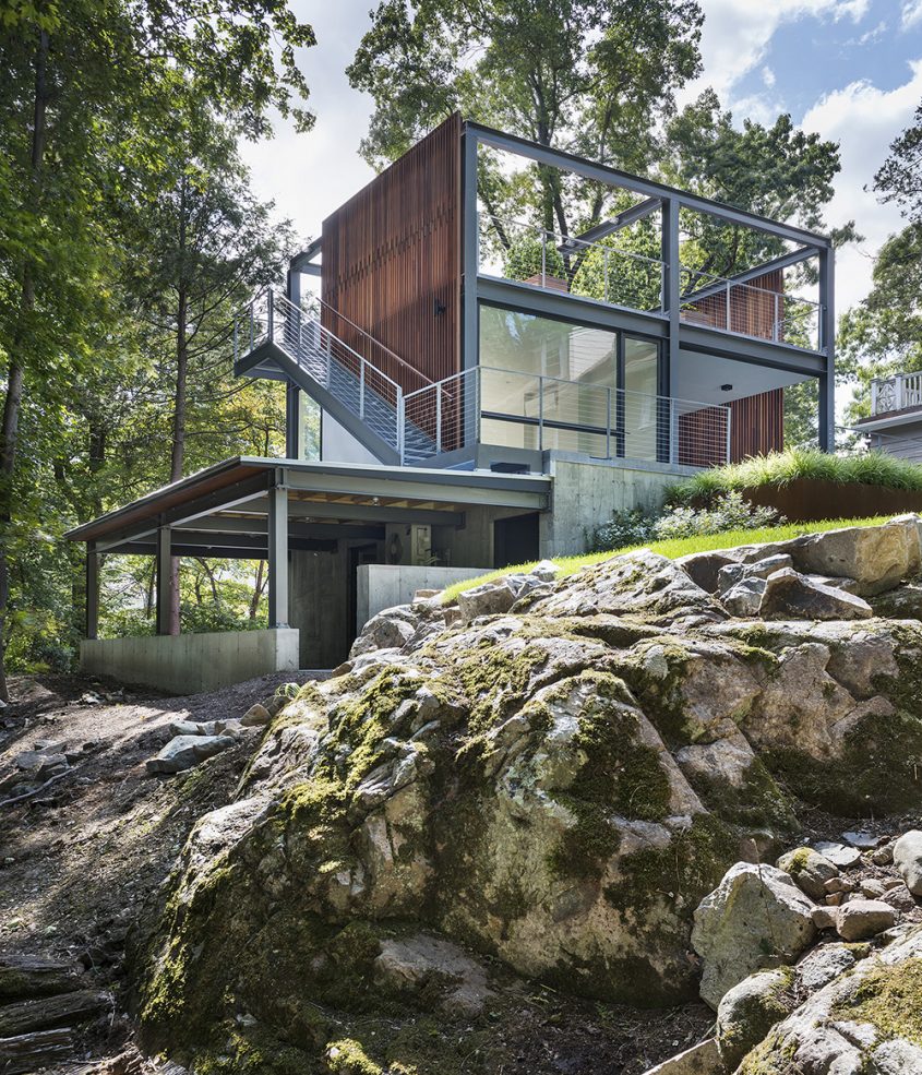 exterior of 3-story garage and studio with rock ledge in foreground