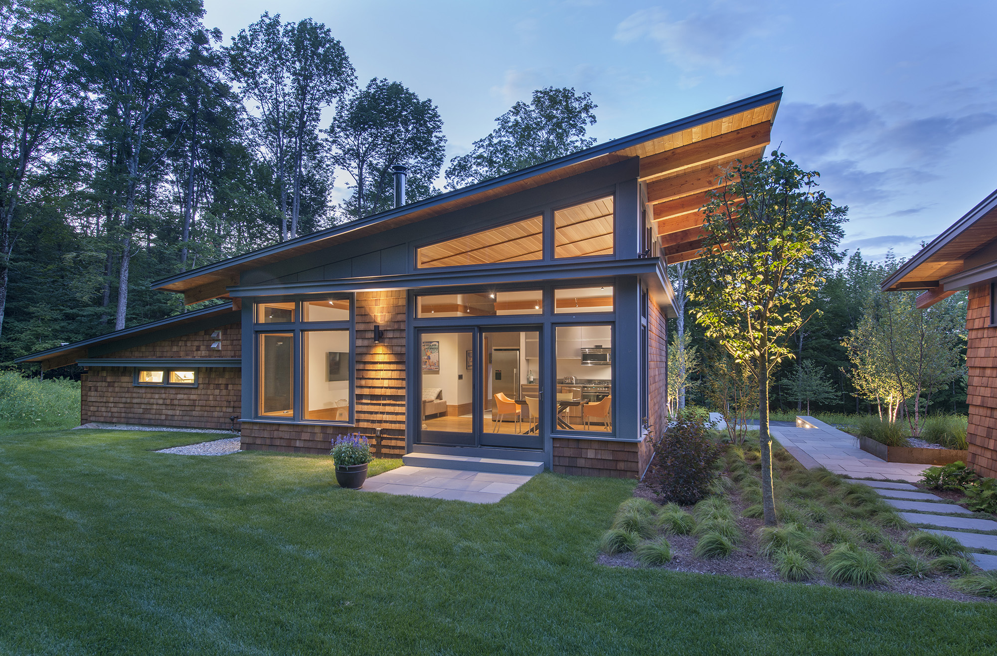 dramatic overhang shed roof guest studio glowing at dusk