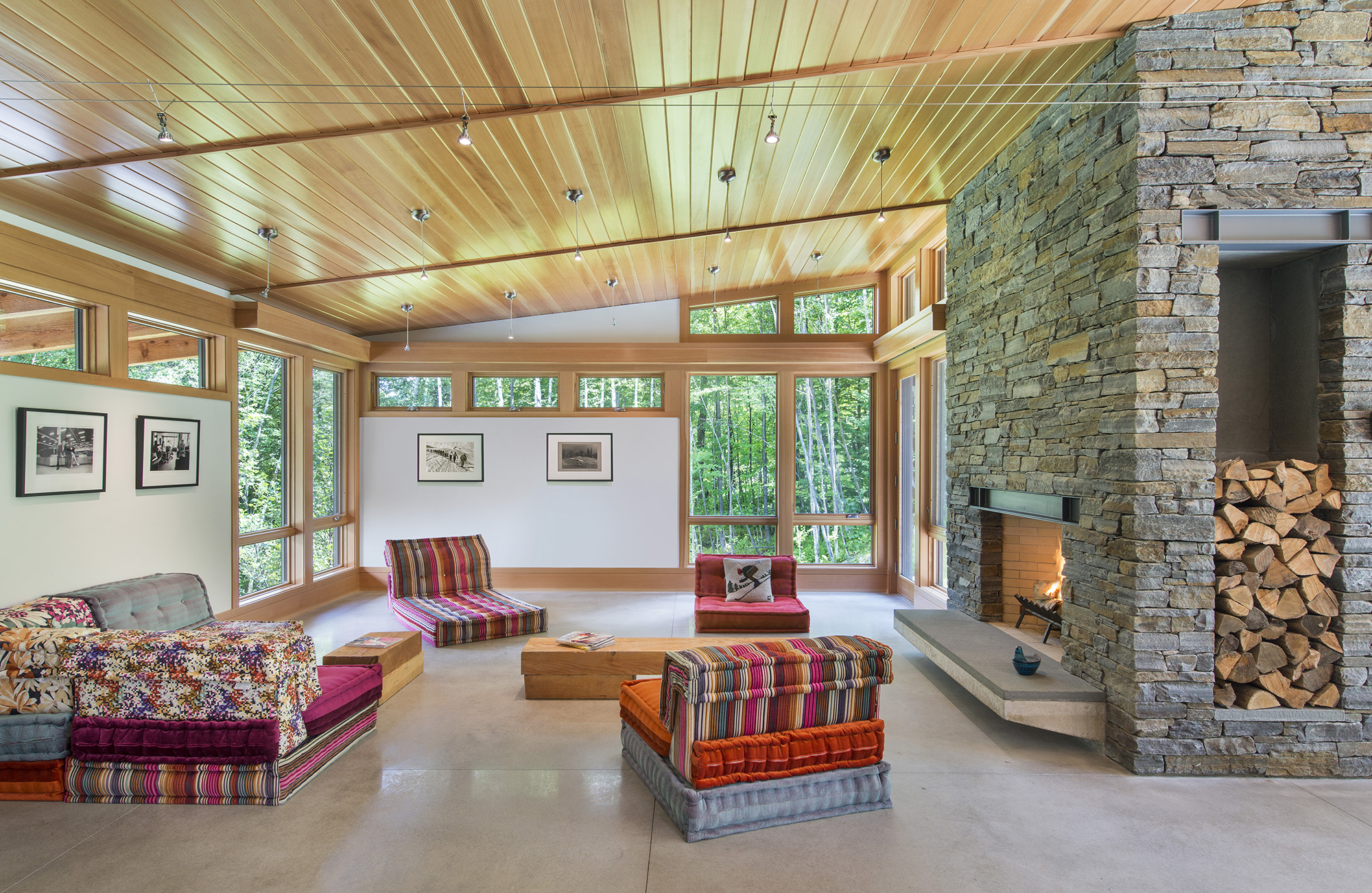 ski chalet living room with wood ceiling and large stone fireplace