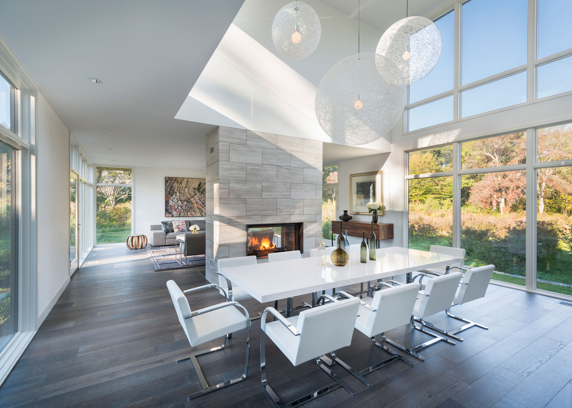 modern dining room with two-sided gas fireplace and 2-story glass windows