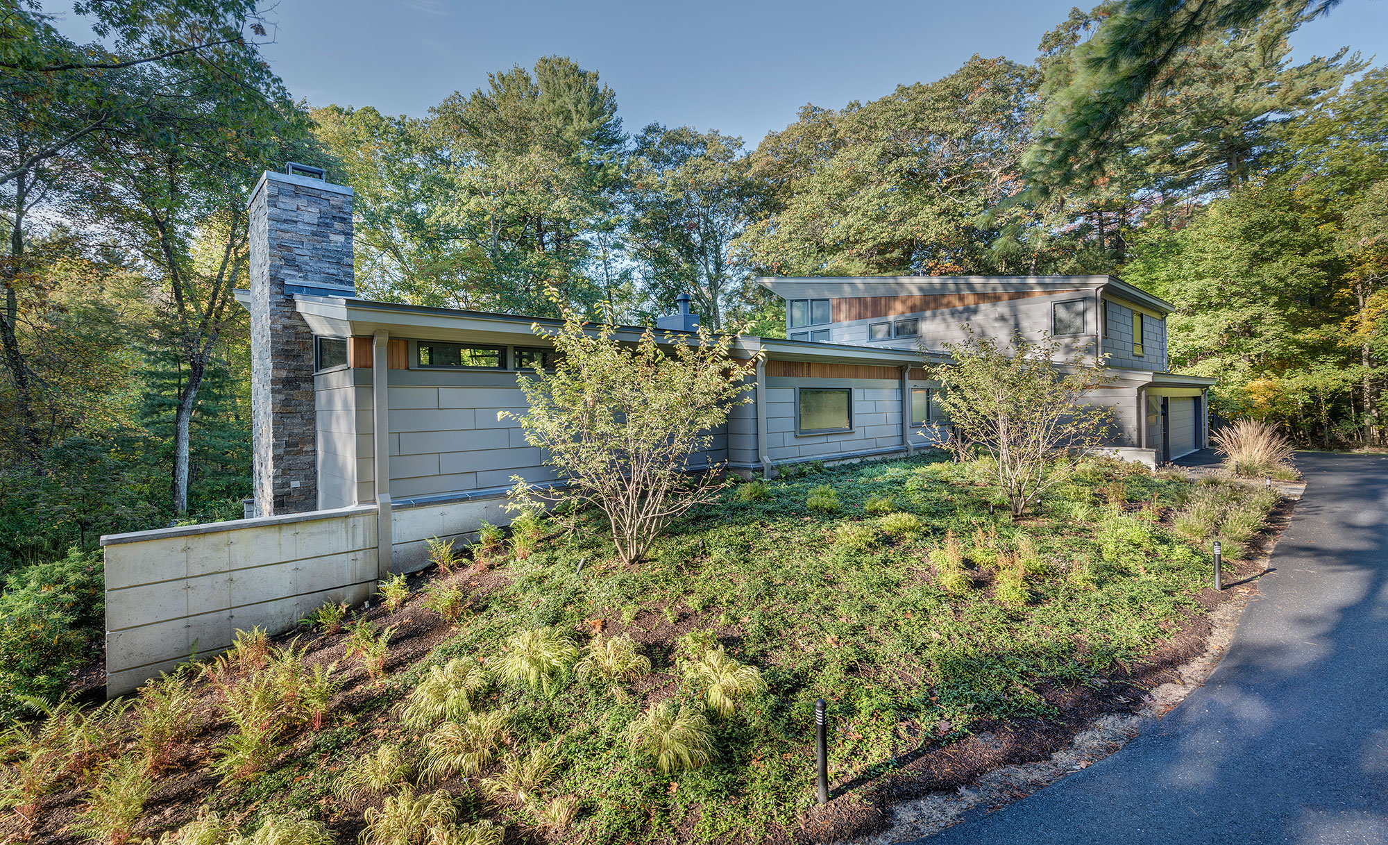 modern home with concrete retaining wall bermed into the landscape