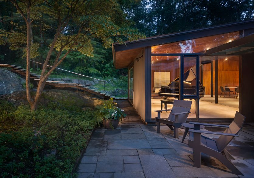 exterior of mid-century modern glowing at dusk grand piano