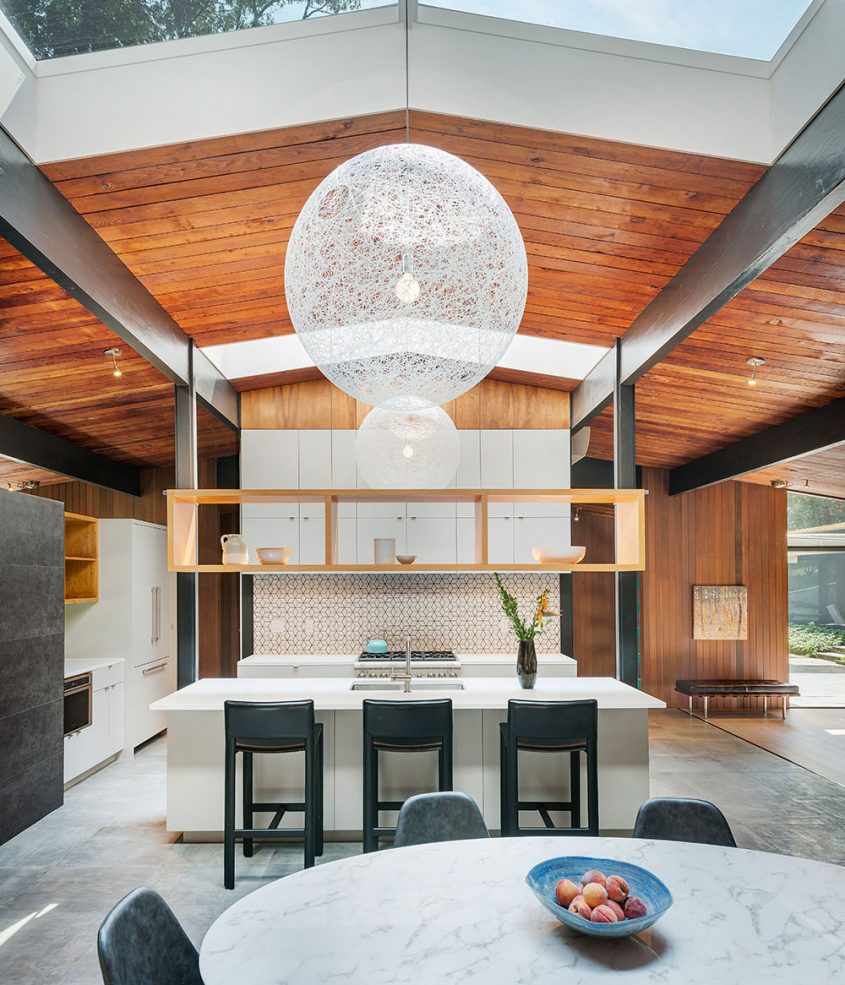 mid-century modern kitchen with large skylights and floating shelving
