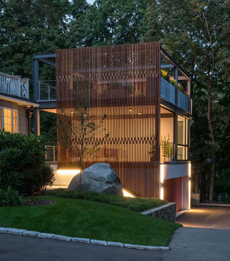 3-story studio and garage glowing at dusk