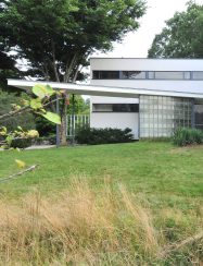 modern home exterior with cantilevered roof entry and sprial staircase
