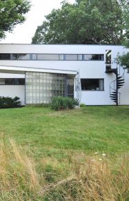 modern home exterior with cantilevered roof entry and sprial staircase