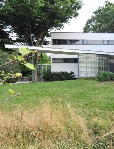 modern home exterior with cantilevered roof entry and sprial staircase