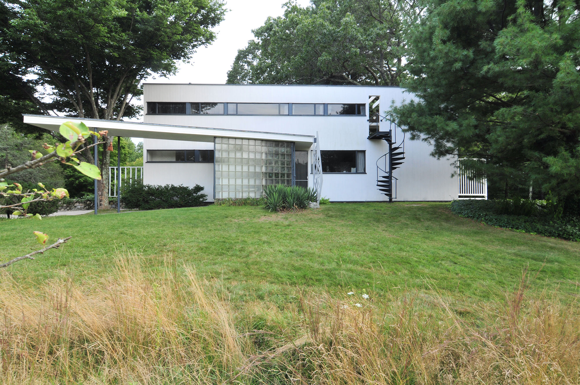 modern home exterior with cantilevered roof entry and sprial staircase