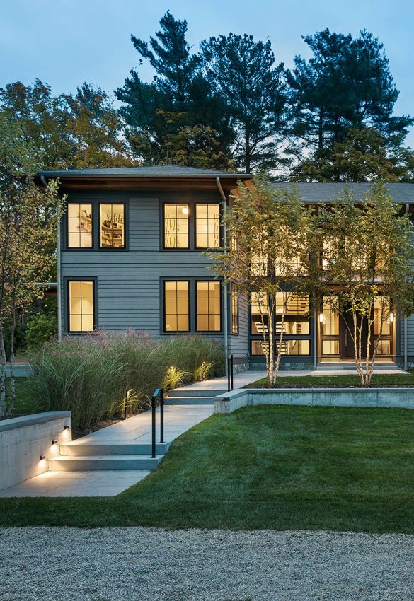 modern exterior home glowing at dusk with birch trees in the foreground