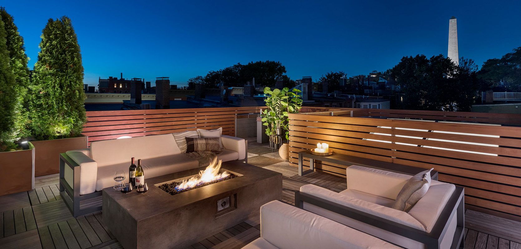 furnished rooftop of row house with gas firepit at dusk