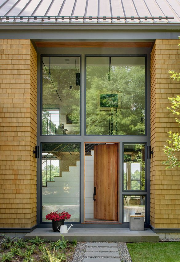 covered front entry of modern farmhouse with cedar shingles