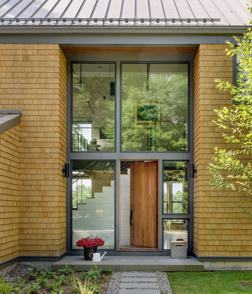 covered front entry of modern farmhouse with cedar shingles