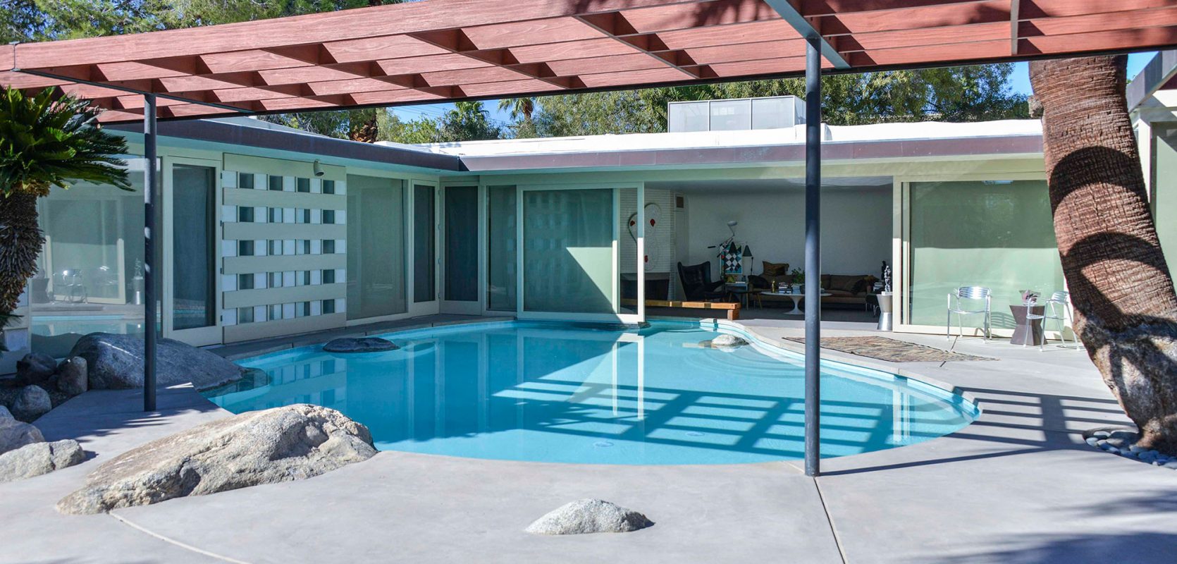 exterior view of mid-century modern home with pool in living room