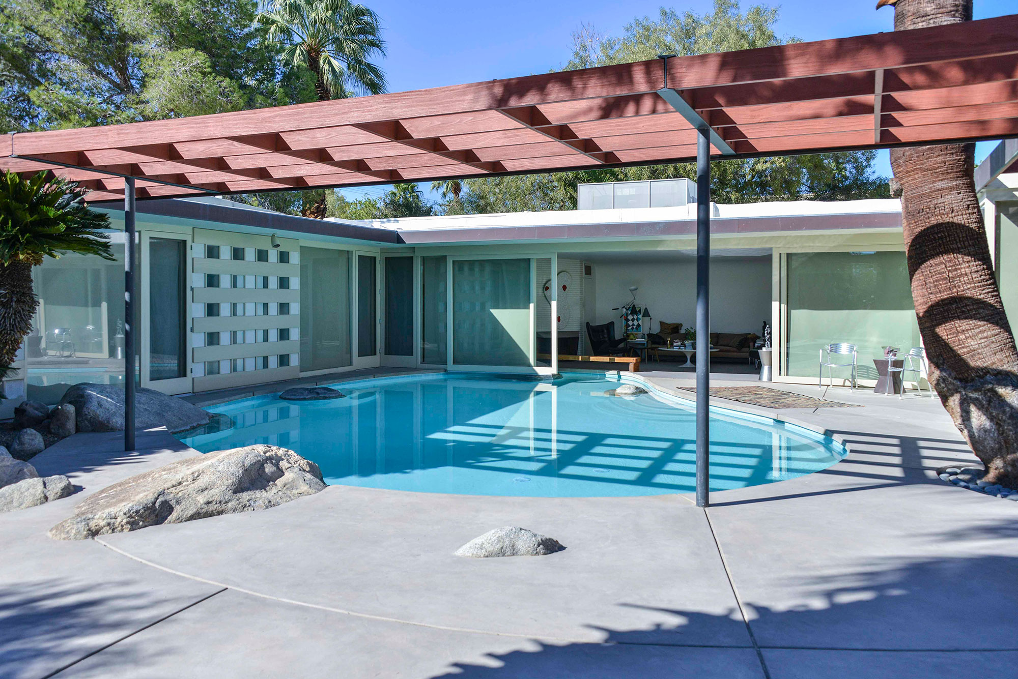 exterior view of mid-century modern home with pool in living room