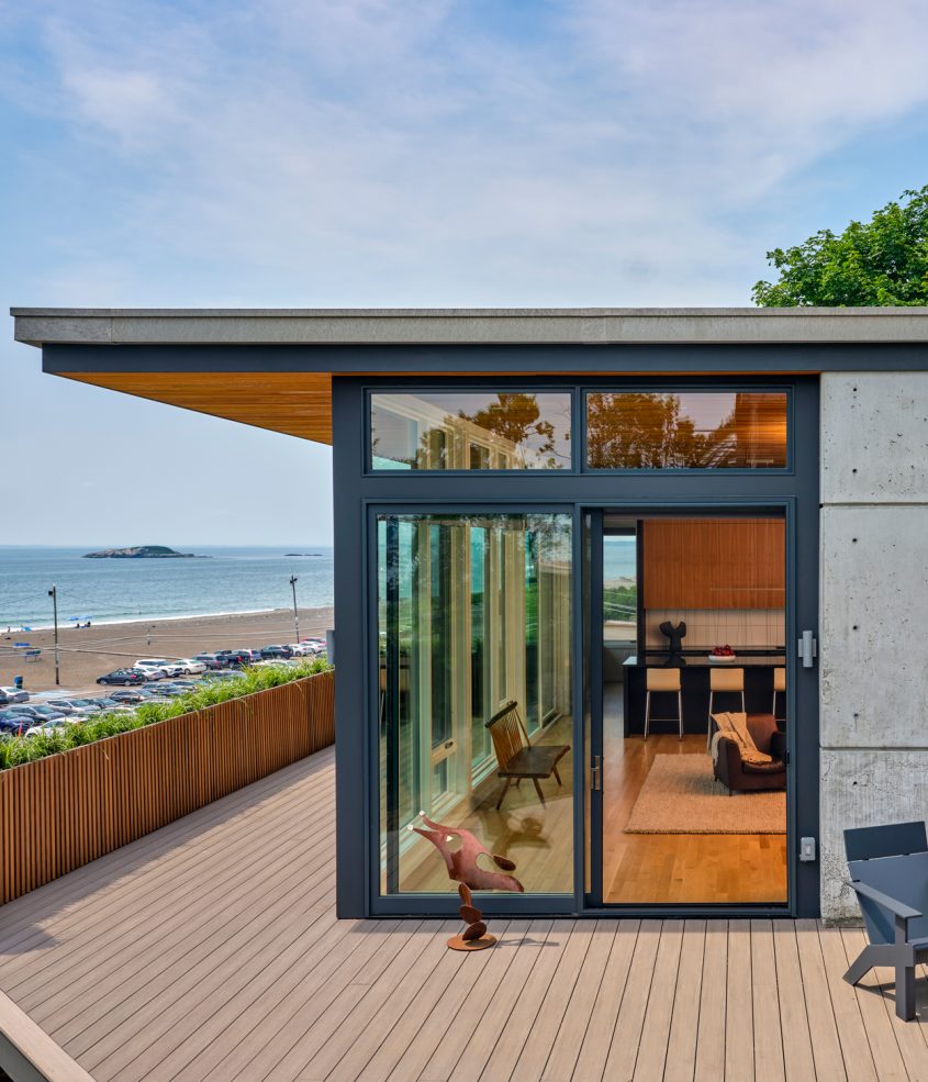 rear corner of home with deck overlooking ocean