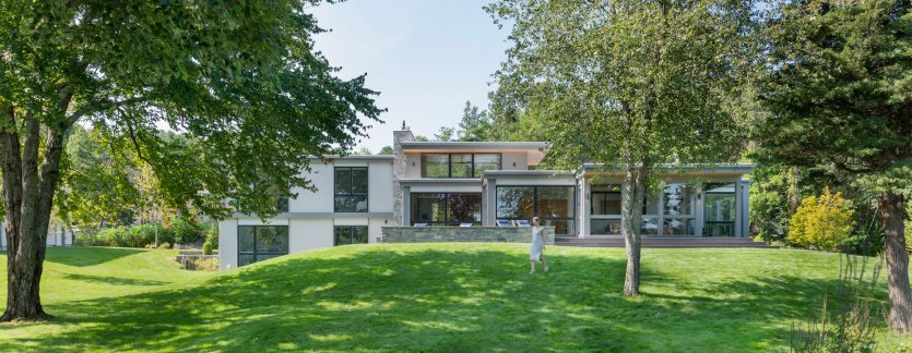 rear elevation of modern home nestled in landscape