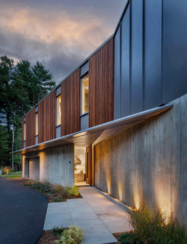 Evening image with contemporary lighting of front driveway and hidden entrance to home interior.