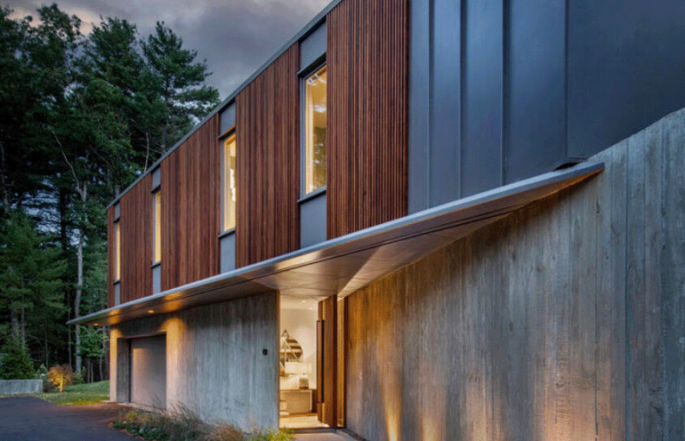 Evening image with contemporary lighting of front driveway and hidden entrance to home interior.