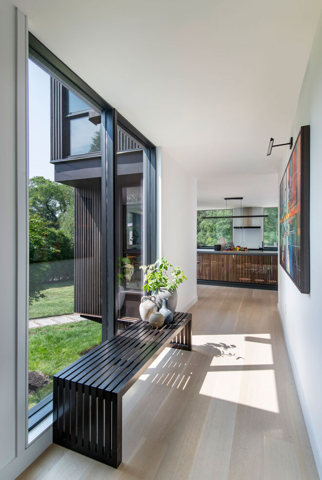 Hallway walkway with large windows for traveling back and forth to and from new addition. Natural Lighting encapsulates the space creating a almost museum like contemporary feel to the space.