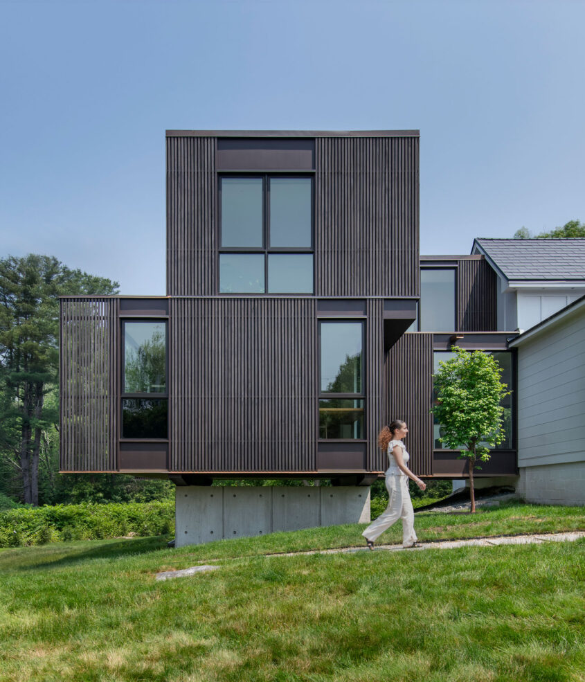 Outdoor elevation photo with resident walking along sidewalk for scale.