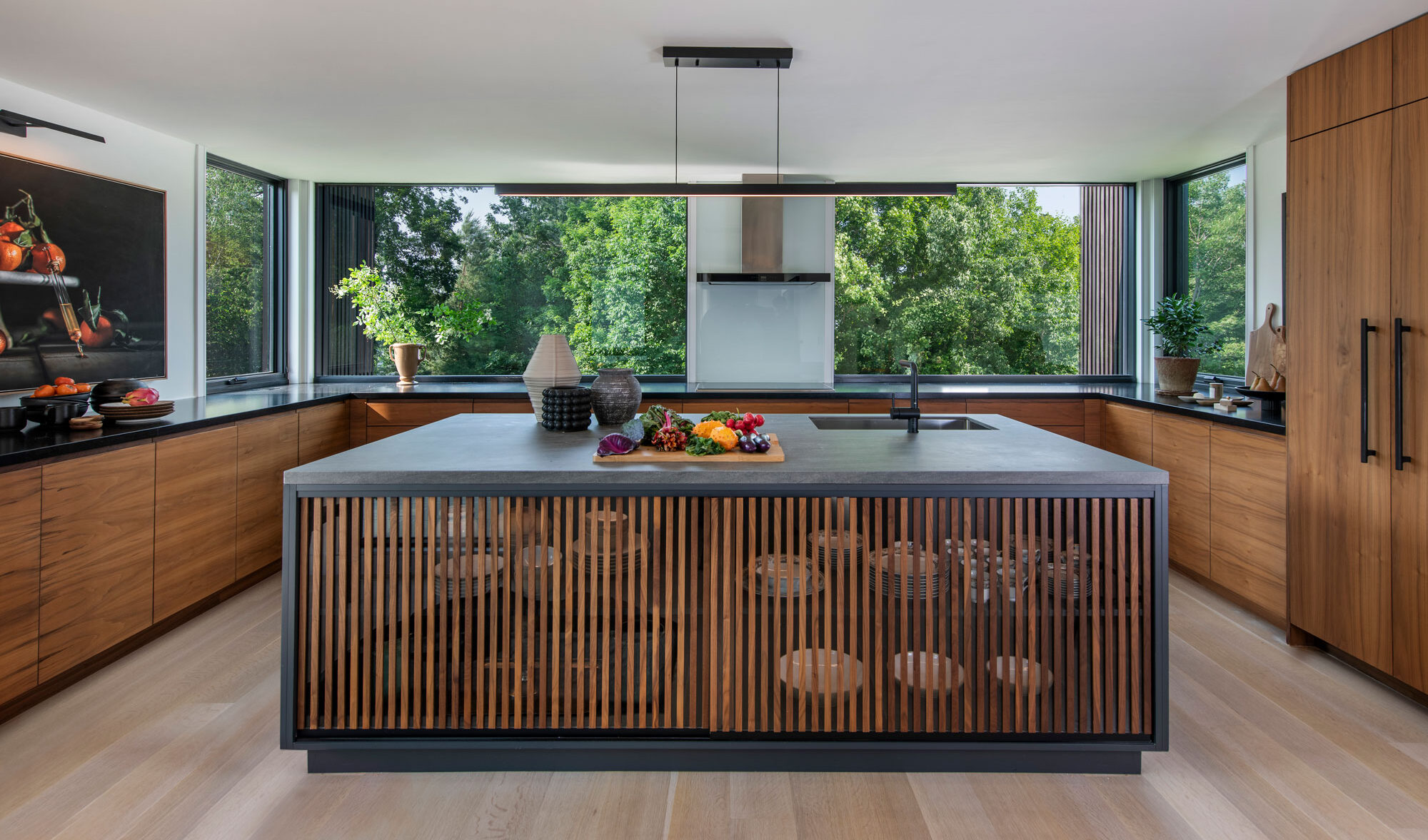 Main kitchen with wood paneled storage space. Natural and minimal the warm materials help create a sense of relaxed but glamourous room environment.