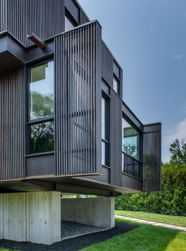 metal paneling creating privacy and contemporary design. Large windows for natural lighting and modern approach.