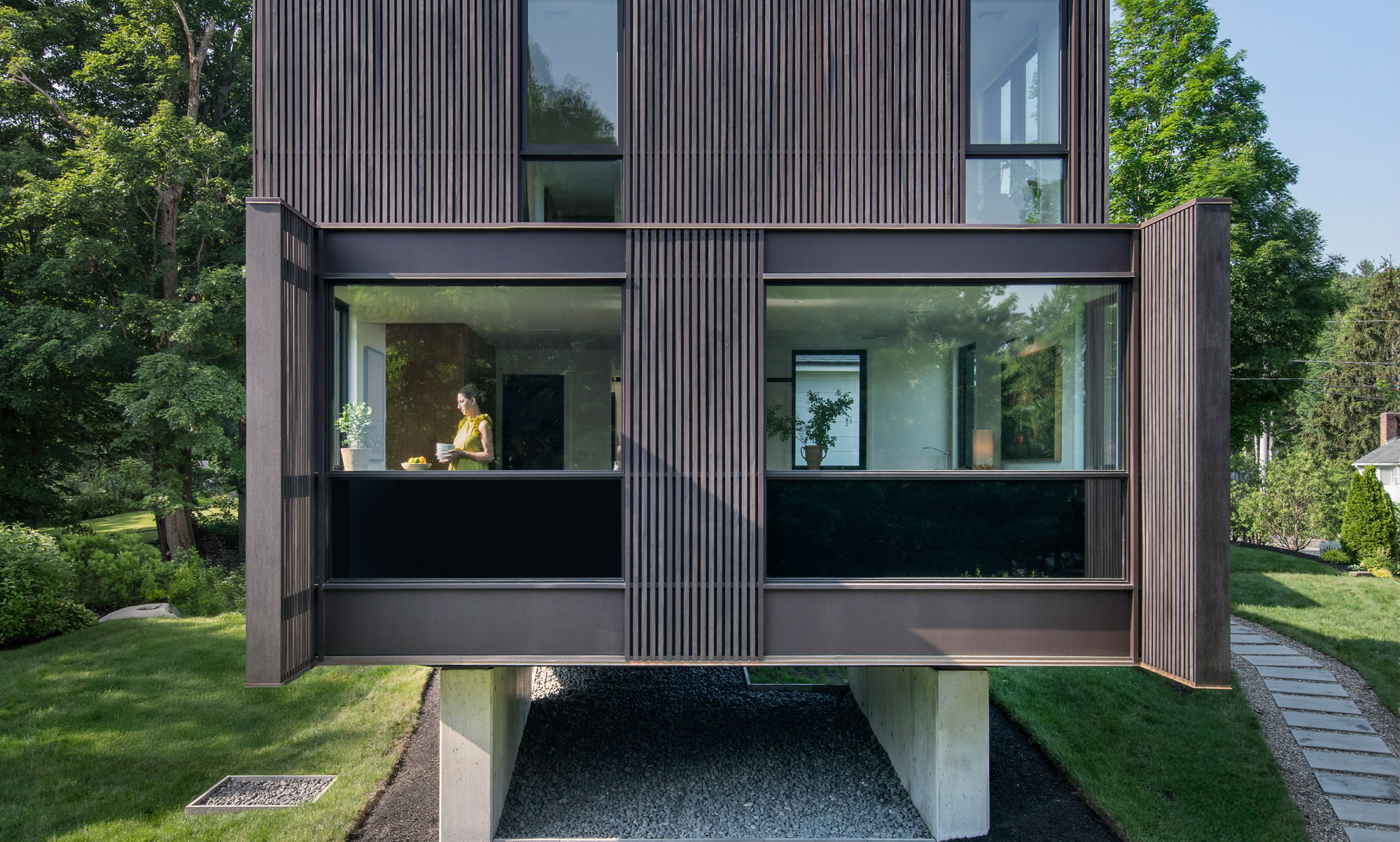 Outdoor elevation photo of kitchen with natural lighting entering interior and shadow cast by paneling.