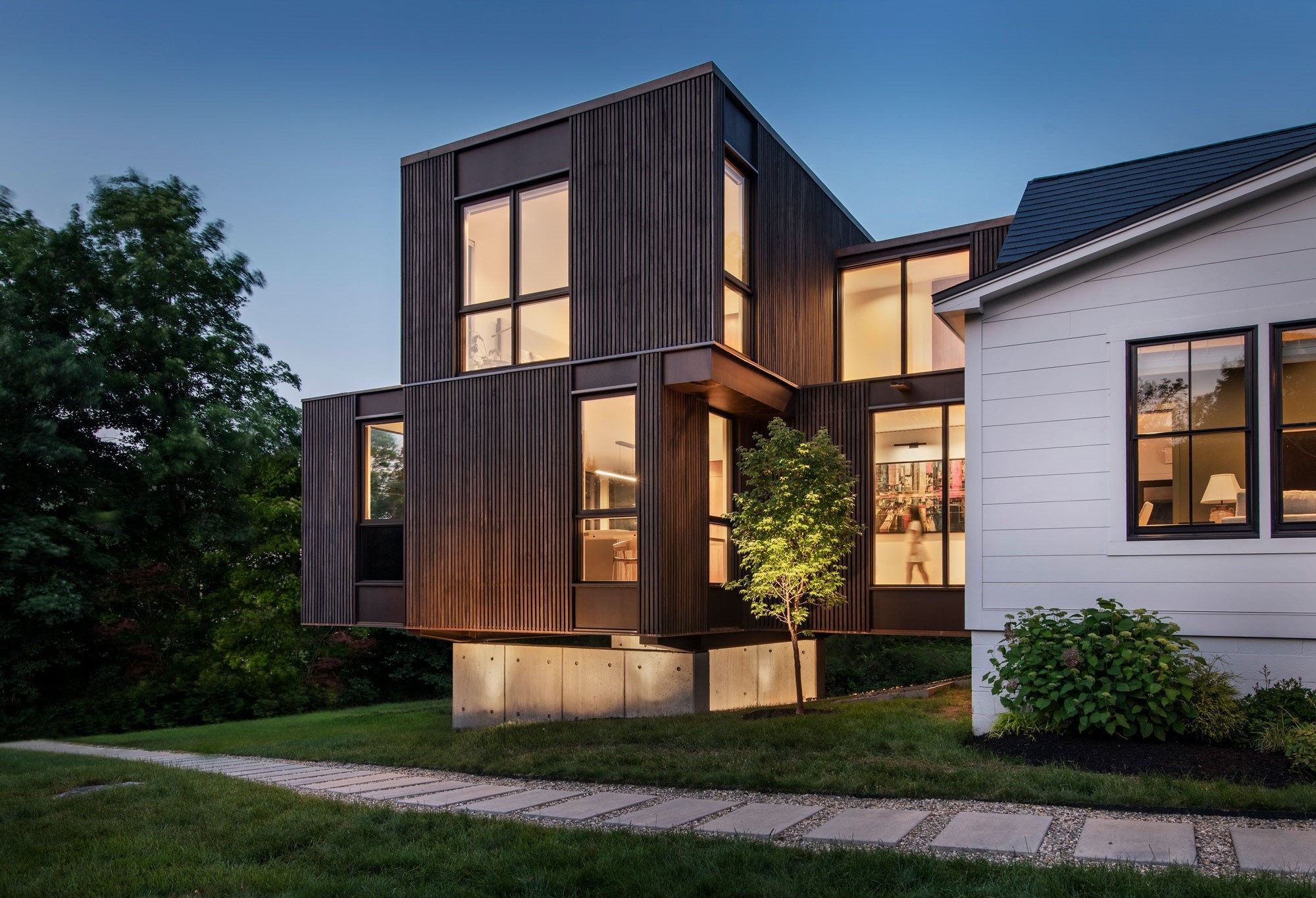 Glowing evening image of Flavin Architects modern addition.